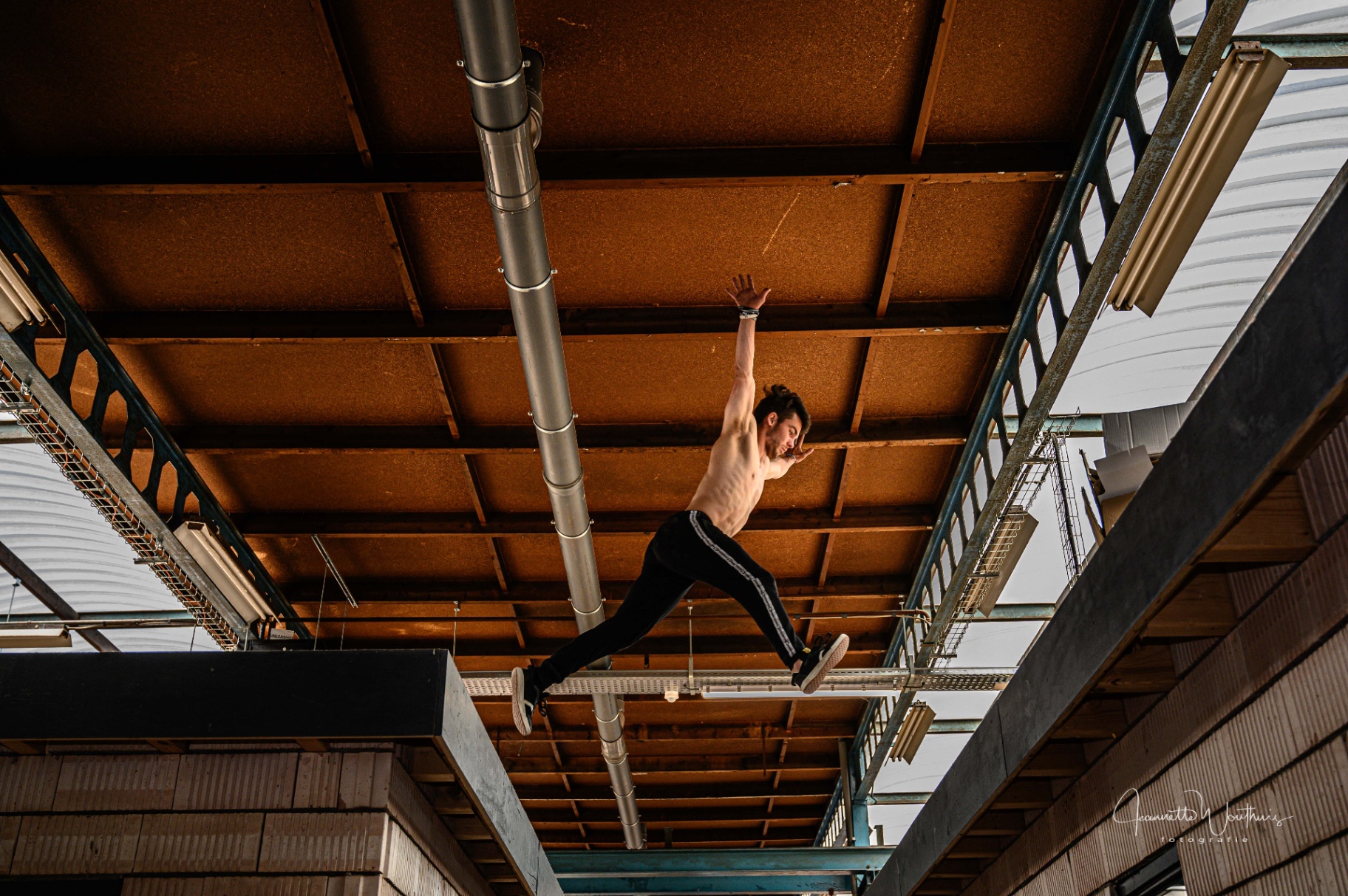 Jongere maakt freerun-sprong onder een industrieel dak